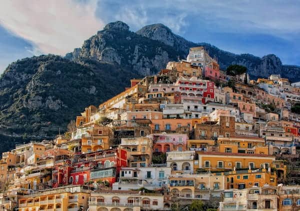 Famous colourful buildings in Positano with great mountains in the background.