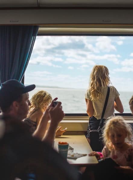 A group of people sitting at a table in front of a window.